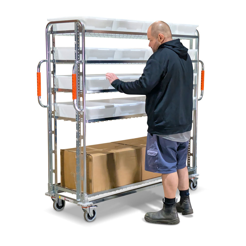 person loading goods into tote on a large heavy duty order picking trolley with adjustable shelves
