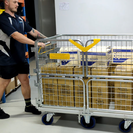 Person pushing a cart with boxes in a warehouse setting
